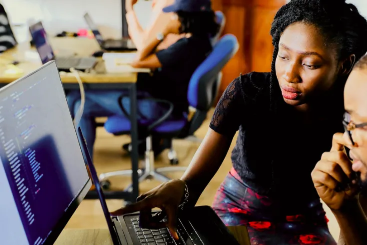 Photo of two student sitting at a computer