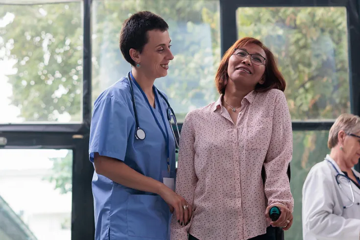 Photo of a nurse helping a patient walk