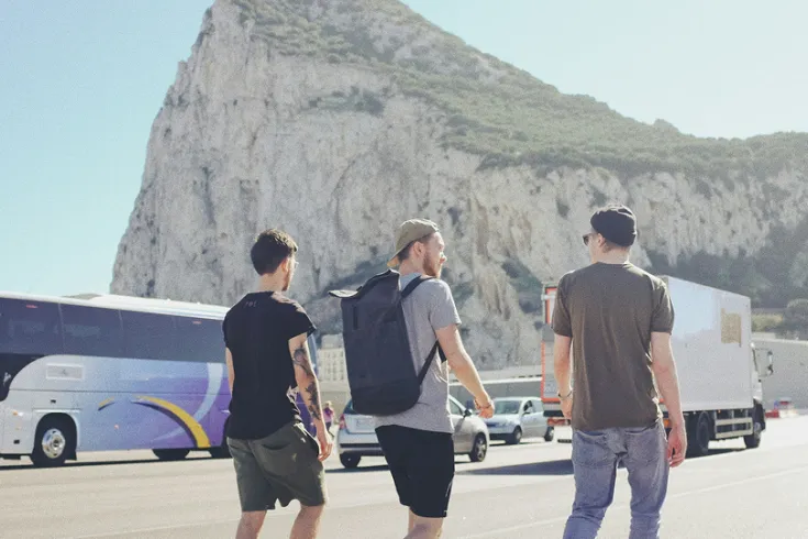 photo of three men standing near to coaches at a tourist attraction