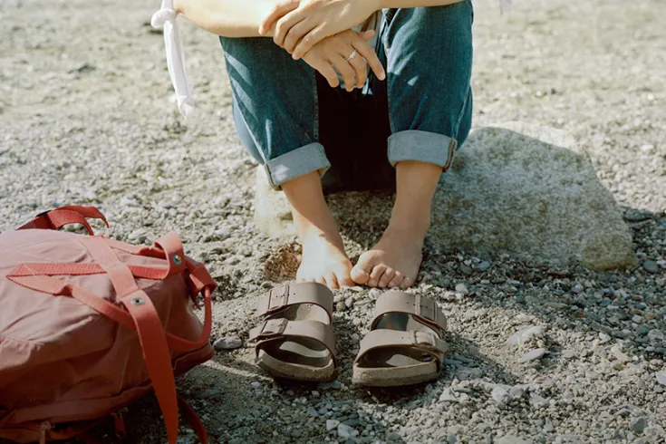 Photo of a person with their shoes off on a beach