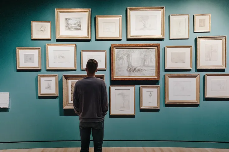 Photo of a man looking at art in a gallery