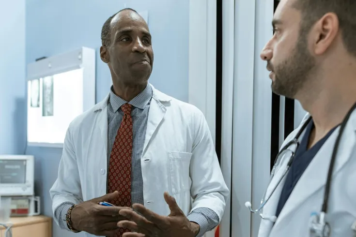 Two doctors talking to each other in a hospital ward