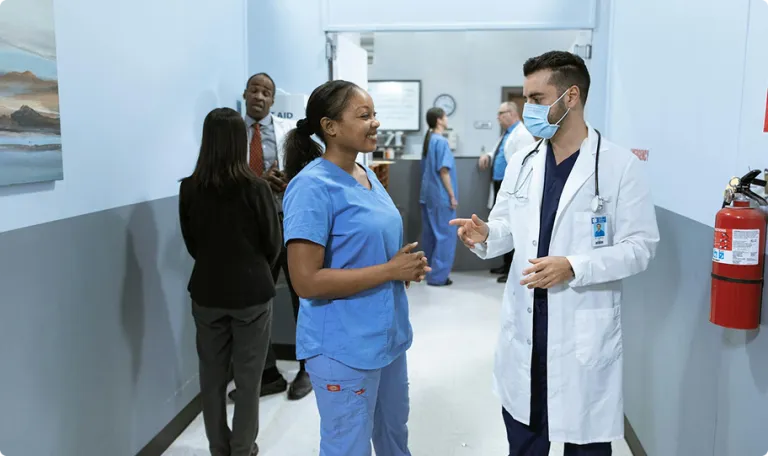 Two doctors talking to each other in a hospital corridor