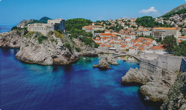 A mediterranean seaside town next to a clear blue sea.