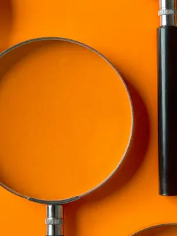 Magnifying glass on an orange background