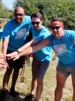 Three members of our team on a team building event putting their hands together