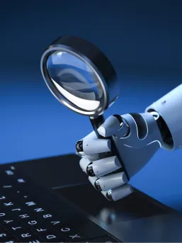 A robotic hand holding a magnifying glass