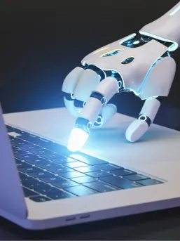 A robotic hand pressing glowing keys on a laptop