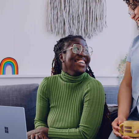 Two people sitting on a sofa chatting