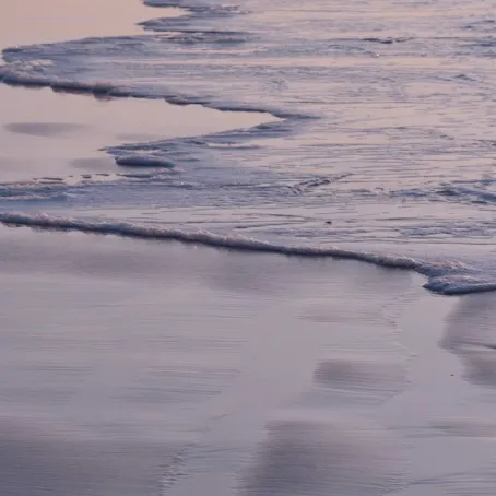 Image of small waves on a shoreline at dusk