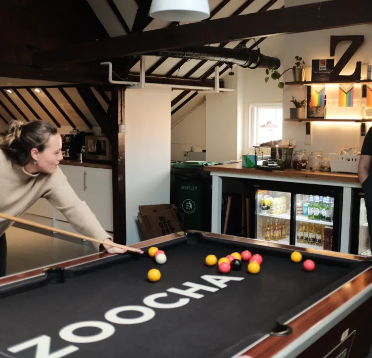Chloe playing pool in the office