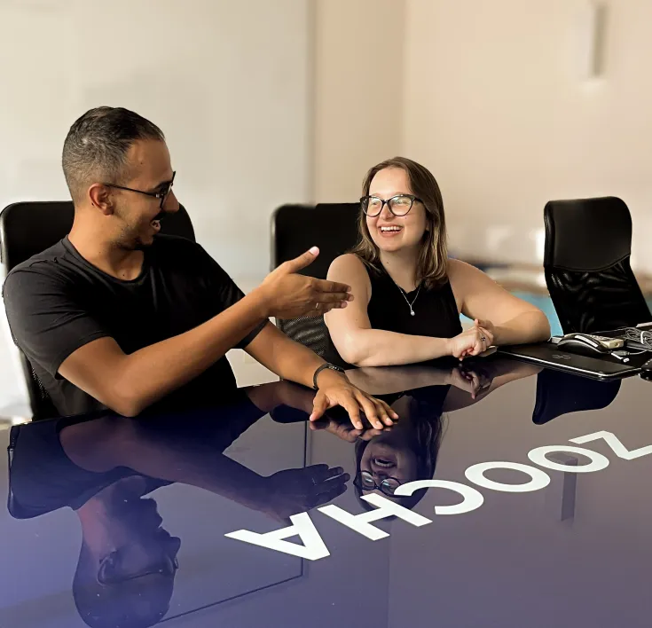 Picture of Nathercia and Uesli talking at a table with Zoocha branding