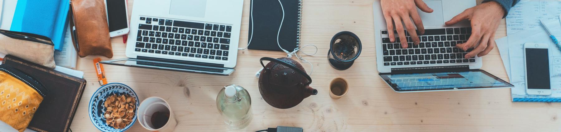 Laptops and coffee across a wooden table