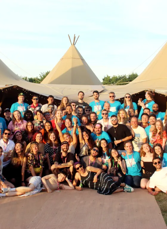 Large team photo outside, it is summer, we are in front of a marquee 