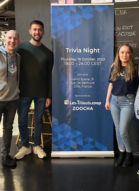 Our team standing in front of our trivia night sponsorship sign