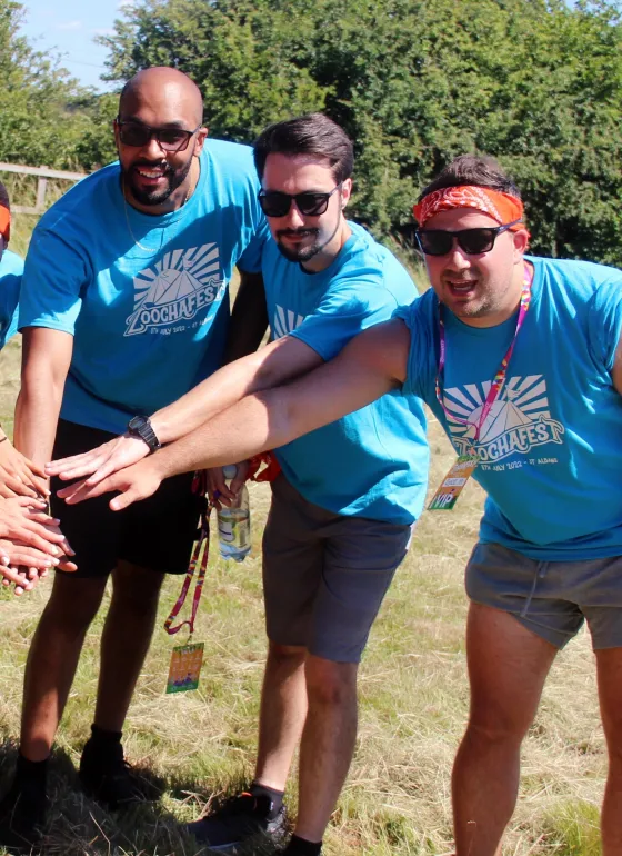 Three members of our team on a team building event putting their hands together