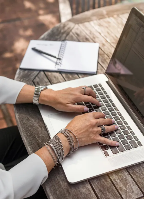 Hands typing on a laptop
