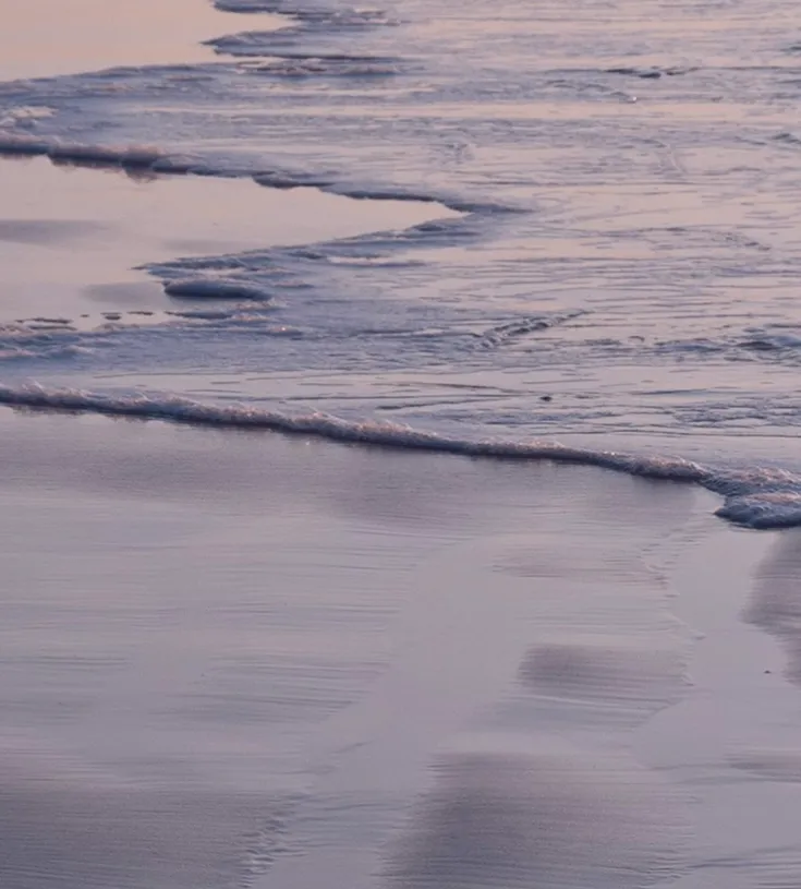 Image of small waves on a shoreline at dusk