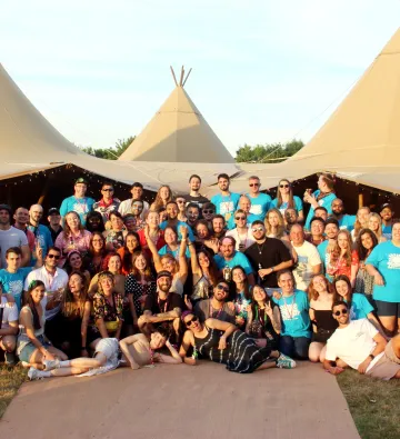 Large team photo outside, it is summer, we are in front of a marquee 