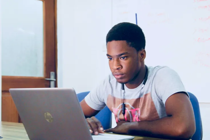 Male student working at a laptop